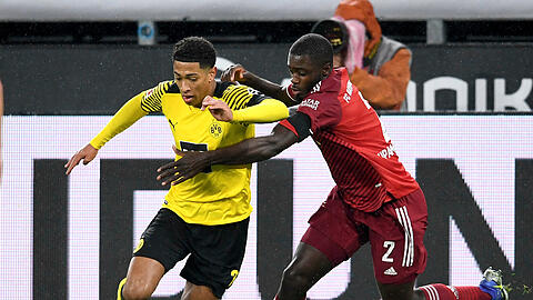 Jude Bellingham (li, Borussia Dortmund) gegen Dayot Upamecano (re, FC Bayern Muenchen).