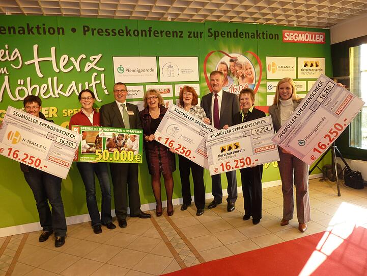 Viel Geld für gute Sachen: Symbolische Scheckübergabe bei Möbel Segmüller.