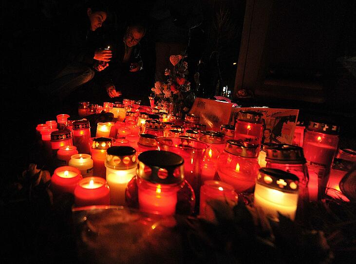 Menschen trauern n Günzburg an einem Bahnübergang. Aus unbekannter Ursache waren dort am 27.12.2012 zwei Mädchen von einem Zug erfasst und getötet worden.