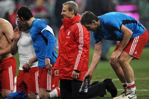 An der Seite seiner "Jungs": Bayern-Trainer Jürgen Klinsmann feiert das 2:1 gegen Hoffenheim und kniet vor den Fans in der Südkurve nieder - rechts von ihm Kapitän Mark van Bommel, links macht es sich gerade Miroslav Klose bequem.