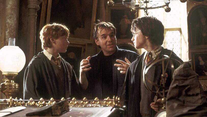 Chris Columbus (m.) am Set mit Rupert Grint (l.) und Daniel Radcliffe.