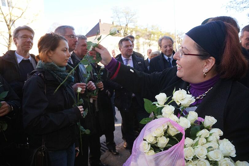Pinar Kilic, die Witwe des 2001 ermordeten Habil Kilic, verteilt an die Anwesenden weiße Rosen.
