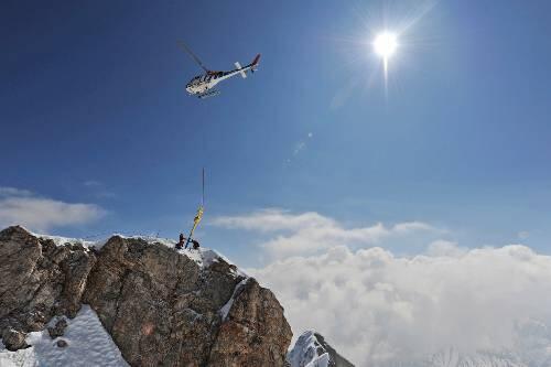 Helikopter über der Zugspitze: Er bringt das frisch renovierte Kreuz zurück auf den Gipfel von Deutschlands höchstem Berg.