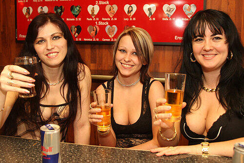Michelle, Carmen und Maria (von links) an der Bar im &bdquo;Mecki Messer&ldquo;: Auf der Leuchttafel im Hintergrund werben die Frauen für ihre Dienste im Laufhaus um die Ecke.