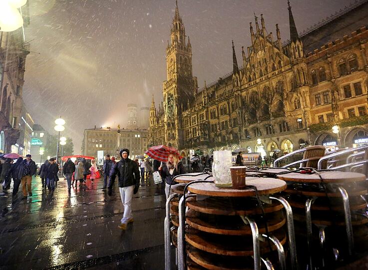 Der Marienplatz am Samstagabend: Schneeflocken und angezuckerte Tische.
