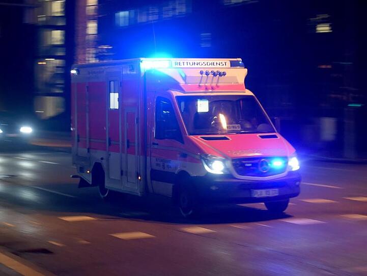 Ein Rettungswagen fährt abends mit Blaulicht über die beleuchtete Straße. Foto: Carsten Rehder/dpa/Symbolbild