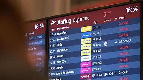Passagiere blicken auf eine Anzeigetafel am Hauptstadtflughafen BER (Symbolbild).