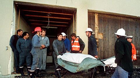 Polizei und Feuerwehrleute tragen am 5. Oktober 1994 die tot aufgefundenen Sektenmitglieder aus dem Haus in Cheiry im Kanton Freiburg. Hier starben zehn Männer, zwölf Frauen und ein Kind.