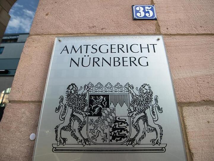Ein Schild mit dem Schriftzug "Amtsgericht Nürnberg" hängt am Eingangsbereich des Amtsgerichts. Foto: Daniel Karmann/dpa