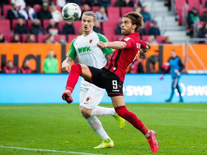 Augsburgs Tin Jedvaj und Freiburgs Lucas Höler (l-r.) in Aktion. Foto: Tom Weller/dpa