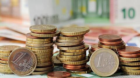 Euro-Münzen auf Euro-Banknoten. Foto: Tobias Hase/dpa/Symbolbild