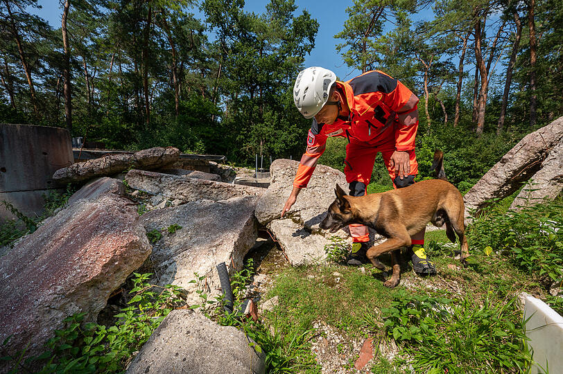 Eric Weiler von der Rettungshundestaffel der Freiwilligen Feuerwehr Hochbrück und sein Hund Benji auf dem ausgebauten Trümmergelände in Garching.