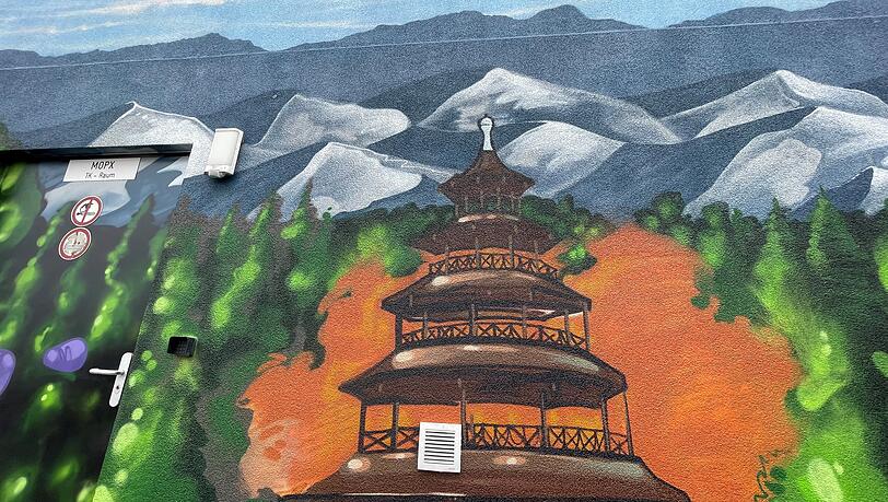 Chinesischer Turm vor schneebedeckten Alpen.