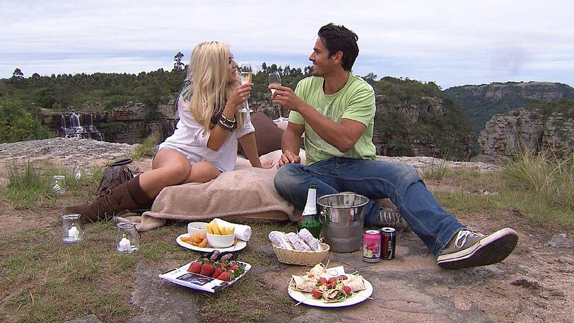 Katies Mut sich der Riesenschaukel zu stellen wird belohnt. Gemeinsam mit dem Bachelor genießt sie bei einem Picknick am Klippenrand die Aussicht auf den Wasserfall.