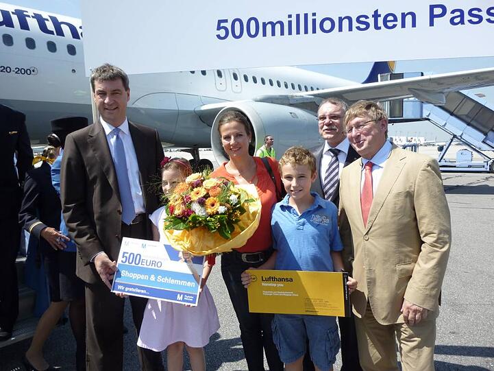 Jubiläums-Passagierin: Cathleen Holsmann nahm den 500-Euro-Gutschein von Minister Markus Söder (l.) und Airport-Chef Michael Kerkloh (r.) entgegen.