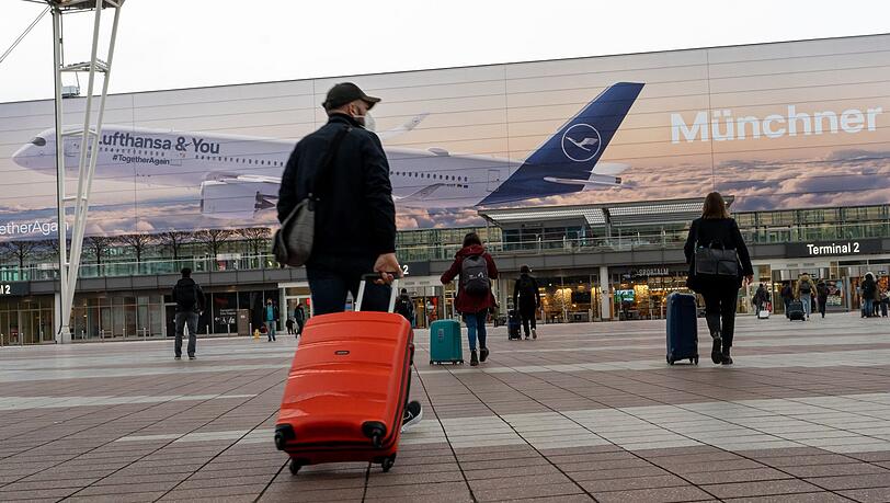 Flugpassagiere gehen zum Abflugterminal 2 des Flughafen München.