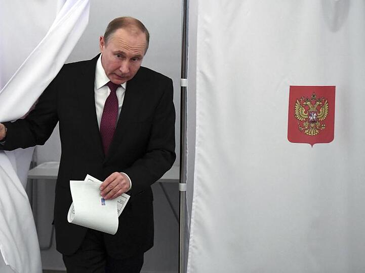 Präsident Wladimir Putin kommt in Moskau aus der Wahlkabine.