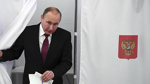 Präsident Wladimir Putin kommt in Moskau aus der Wahlkabine.
