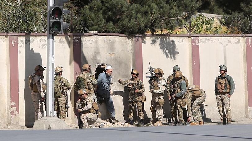 Soldaten helfen in Kabul (Afghanistan) einem Mann das Gelände des TV-Senders Schamschad zu verlassen. Unbekannte haben in der afghanischen Hauptstadt den TV-Sender angegriffen.