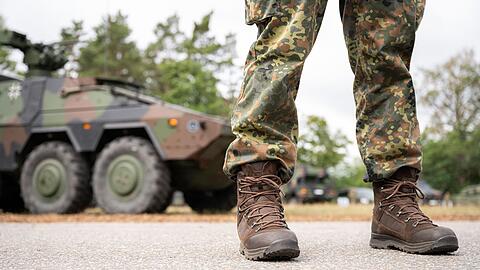 Ein Bundeswehrsoldat steht vor einem Militärfahrzeug (Symbolbild).