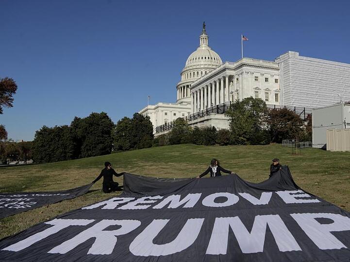 Demonstranten fordern mit einem Banner vor dem Kapitol das politische Ende von US-Präsident Trump.