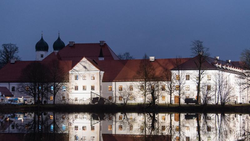 Das beleuchtete Kloster Seeon spiegelt sich im Wasser. Foto: Matthias Balk/dpa/Archivbild Das beleuchtete Kloster Seeon spiegelt sich im Wasser. Foto: Matthias Balk/dpa/Archivbild