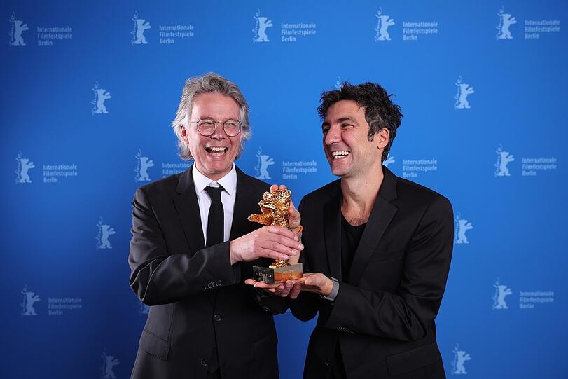 Noch einmal vor der Fotowand: Ilker Catak und der Filmproduzent Ingo Fliess nach der B&auml;ren-Gala der 76. Berlinale.