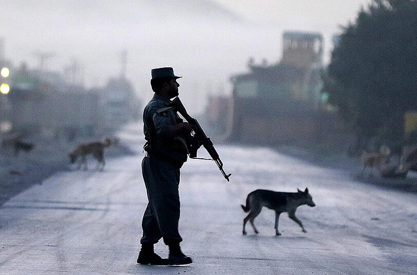 Ein afghanischer Polizist bewacht eine Straße in Kabul, die zu der Unterkunft führt, in der die Gäste des Hotels untergebracht sind, das jüngst von Taliban angegriffen wurde.
