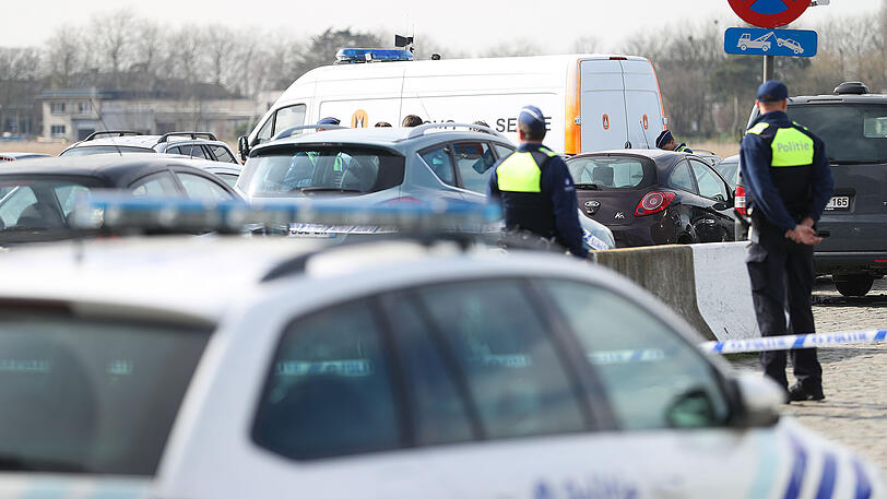 Polizisten und Mitarbeiter des Kampfmittelräumdienstes der belgischen Armee (DOVO) stehen am Donnerstag auf einem Parkplatz in Sint-Michielskaai bei Antwerpen.