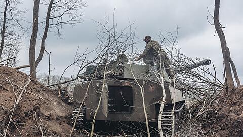 Ein ukrainischer Soldat steigt auf einen Schützenpanzer im Donbass.