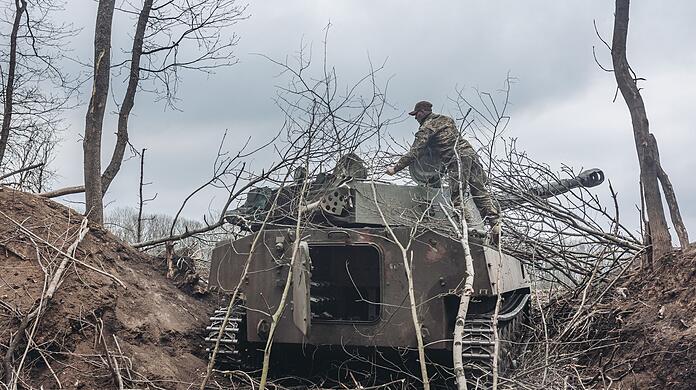 Ein ukrainischer Soldat steigt auf einen Schützenpanzer im Donbass.