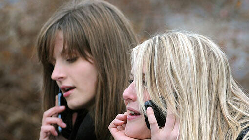 Zwei junge Mädchen telefonieren mit ihren Handys - wie gefährlich ist die Strahlung? Zwei junge Mädchen telefonieren mit ihren Handys - wie gefährlich ist die Strahlung?