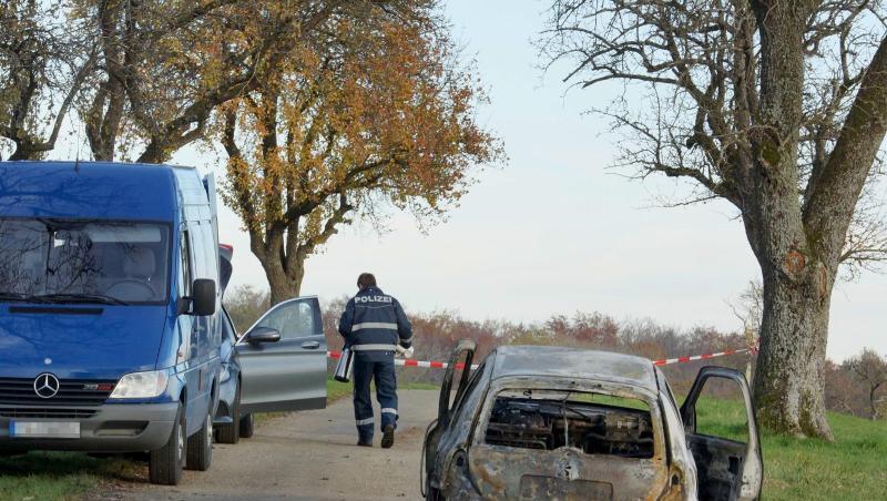 Polizisten stehen neben dem völlig ausgebrannten Fahrzeug außerhalb von Gerabronn. Polizisten stehen neben dem völlig ausgebrannten Fahrzeug außerhalb von Gerabronn.