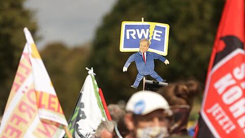 Banner und Selbstgebastelte Schilder: NRW-Ministerpräsident Armin Laschet als Marionette von RWE.