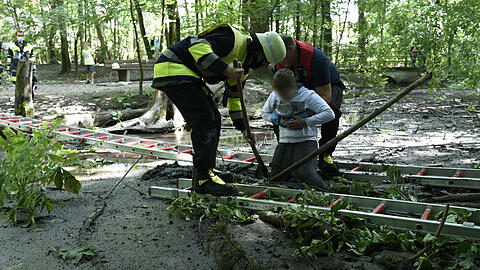 Mit vereinten Kräften zogen die Feuerwehrleute den Zehnjährigen aus dem Schlamm.