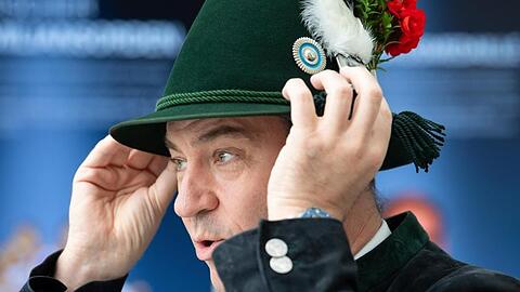 Markus Söder (CSU), Ministerpräsident von Bayern, setzt sich einen Schützenhut der bayerischen Gebirgsschützen auf. Foto: Sven Hoppe/dpa