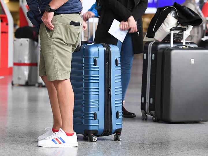 Flugreisende am Check-in-Schalter eines Flughafens.