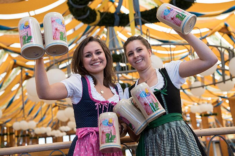 Im Bräurosl-Zelt präsentieren Laura (l) und Maja den Wiesn-Maßkrug 2016.