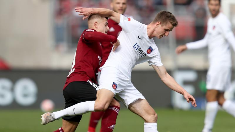 Nürnbergs Nikola Dovedan (l) kämpft mit Heidenheims Jan Schöppner um den Ball.