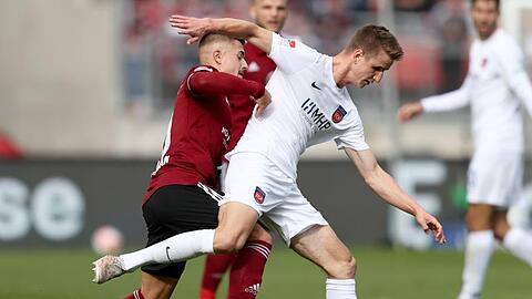 Nürnbergs Nikola Dovedan (l) kämpft mit Heidenheims Jan Schöppner um den Ball.