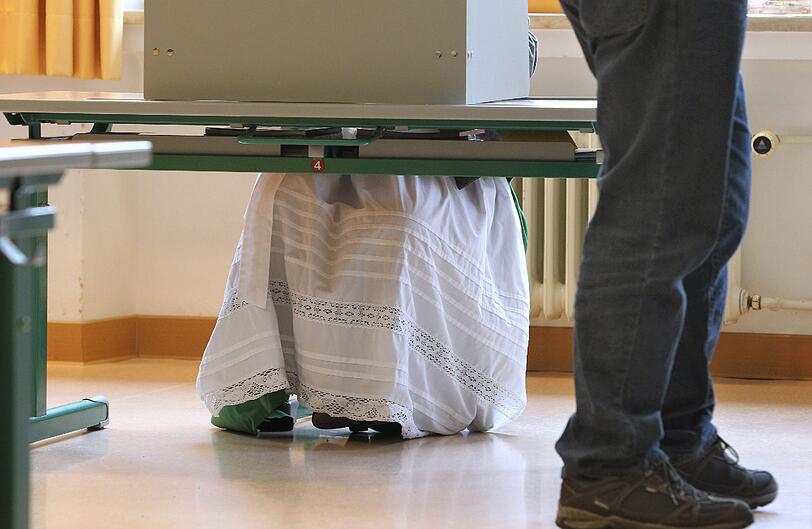 Eine Frau in Tracht wählt in einer Schule in Unterammergau.