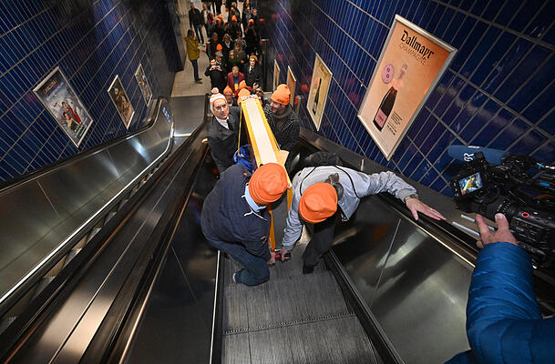Das Schild der Lach- und Schießgesellschaft wird von Mitgliedern der Münchner Lach- und Schießgesellschaft auf einem Leiterwagen auf einer Rolltreppe zur S-Bahn Station Marienplatz gebracht. Die Münchner Lach- und Schießgesellschaft zieht mit U-Bahn und S-Bahn von der Haimhauserstraße zur Fat Cat (Alter Gasteig) am Rosenheimer Platz um. Das Schild der Lach- und Schießgesellschaft wird von Mitgliedern der Münchner Lach- und Schießgesellschaft auf einem Leiterwagen auf einer Rolltreppe zur S-Bahn Station Marienplatz gebracht. Die Münchner Lach- und Schießgesellschaft zieht mit U-Bahn und S-Bahn von der Haimhauserstraße zur Fat Cat (Alter Gasteig) am Rosenheimer Platz um.