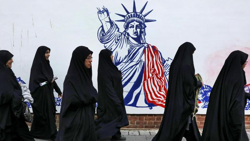 Die Teilnehmerinnen einer Trauerzeremonie für den getöteten General Soleimani gehen auf ihrem Heimweg an der satirischen Zeichnung einer verstümmelten Freiheitsstatue vorbei. Die Teilnehmerinnen einer Trauerzeremonie für den getöteten General Soleimani gehen auf ihrem Heimweg an der satirischen Zeichnung einer verstümmelten Freiheitsstatue vorbei.