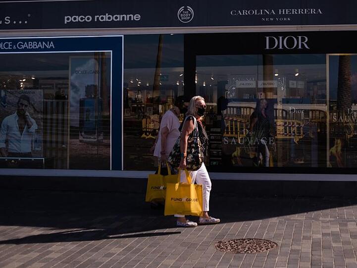Zwei Frauen mit Mundschutz gehen in der Nähe von Playa Martinez in Santa Cruz de Tenerife shoppen. Auf den Kanarischen Inseln ist ein neuer Rekord an Neuinfektionen registriert worden.