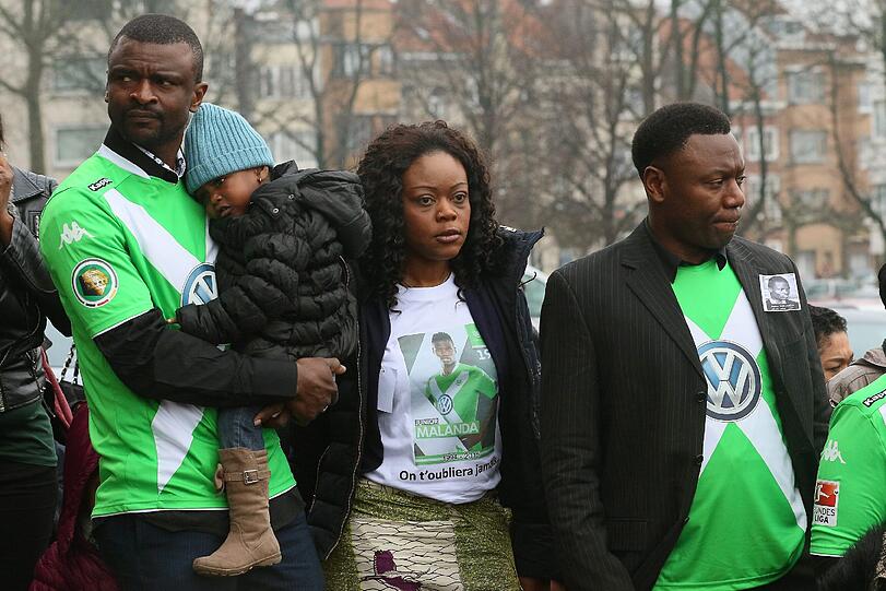 Verwandte nehmen in Wolfsburg-Trikots Abschied von Junior Malanda.