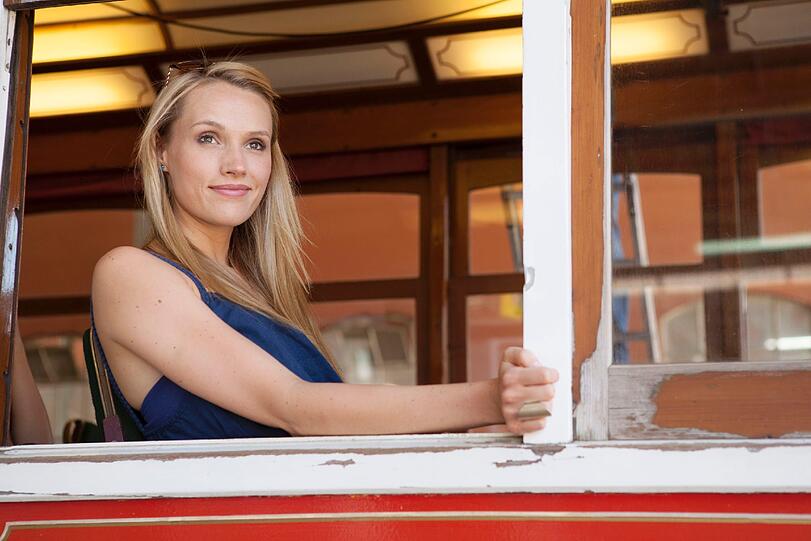Anna in Lissabon. Mit einer historischen Straßenbahn holt sie die Männer ab.