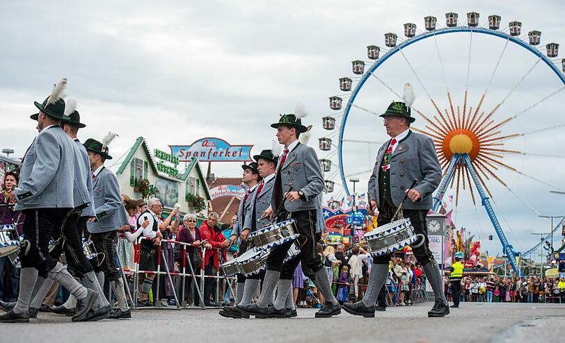 Trotz Nieselwetters rollten rund 40 Festwagen und Kutschen in dem sieben Kilometer langen Zug mit - und die Trachtler aus der ganzen Welt hatten dabei beste Laune.