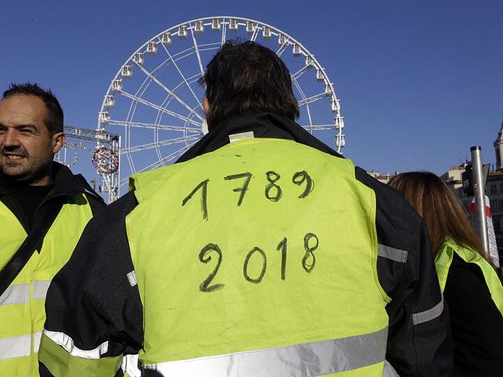 Ein Demonstrant der "Gelbwesten" hat die Jahreszahlen "1789" und "2018" auf seine Weste geschrieben in Anlehnung an die Französische Revolution von 1789.