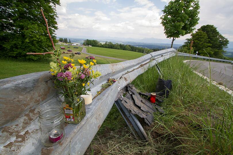 Freunde haben Blumen und Kerzen zur Unfallstelle gebracht. Der Z4 rammte diese Leitplanke am Hohen Peißenberg, bevor er sich auf der Wiese mehrere Male überschlug.