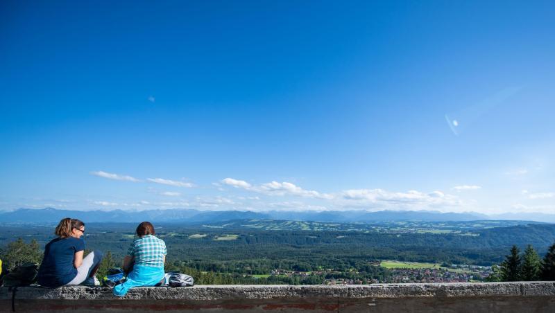 Zwei junge Frauen unterhalten sich vor dem Alpenpanorama, während sie auf einer Mauer sitzen. Foto: Lino Mirgeler/dpa/Archivbild Zwei junge Frauen unterhalten sich vor dem Alpenpanorama, während sie auf einer Mauer sitzen. Foto: Lino Mirgeler/dpa/Archivbild